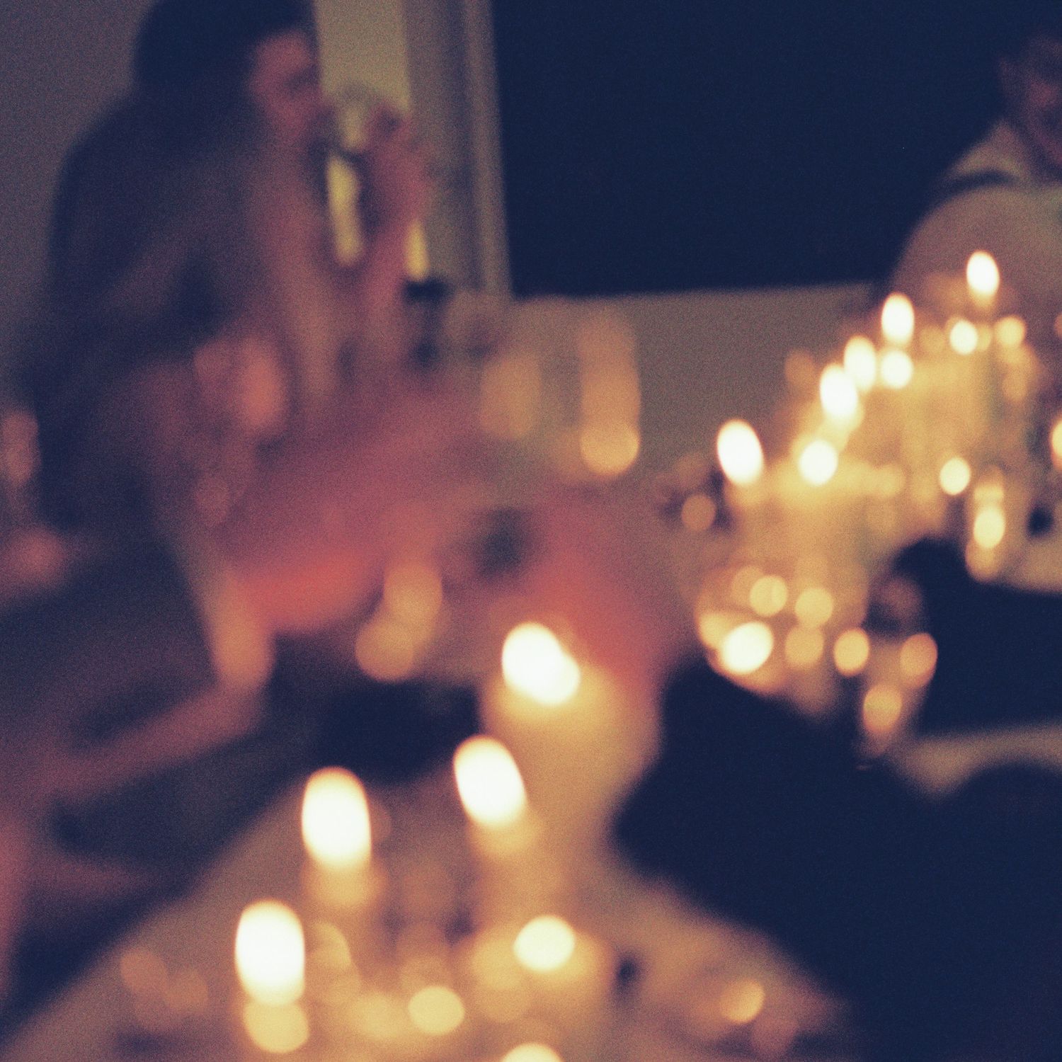 Candlelit dinner table setting with soft glowing lights creating an intimate and romantic atmosphere.