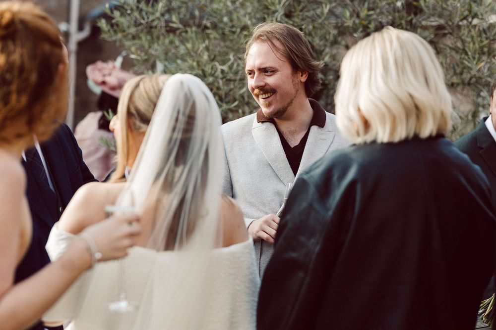 Wedding guests mingle and socialize during an outdoor reception celebration.