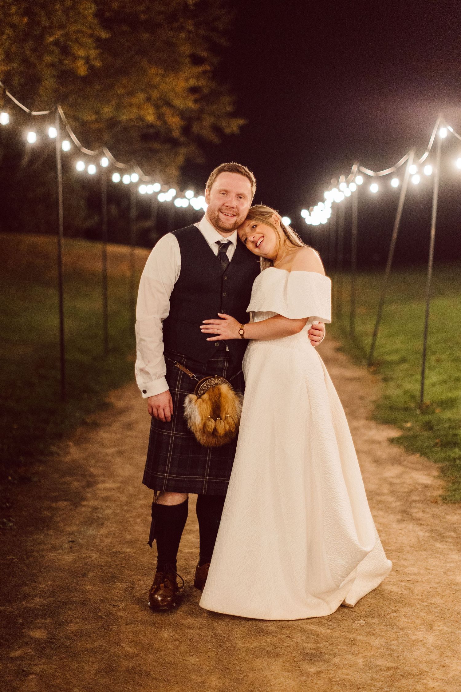 A romantic nighttime wedding photo series showing a couple embracing under string lights.