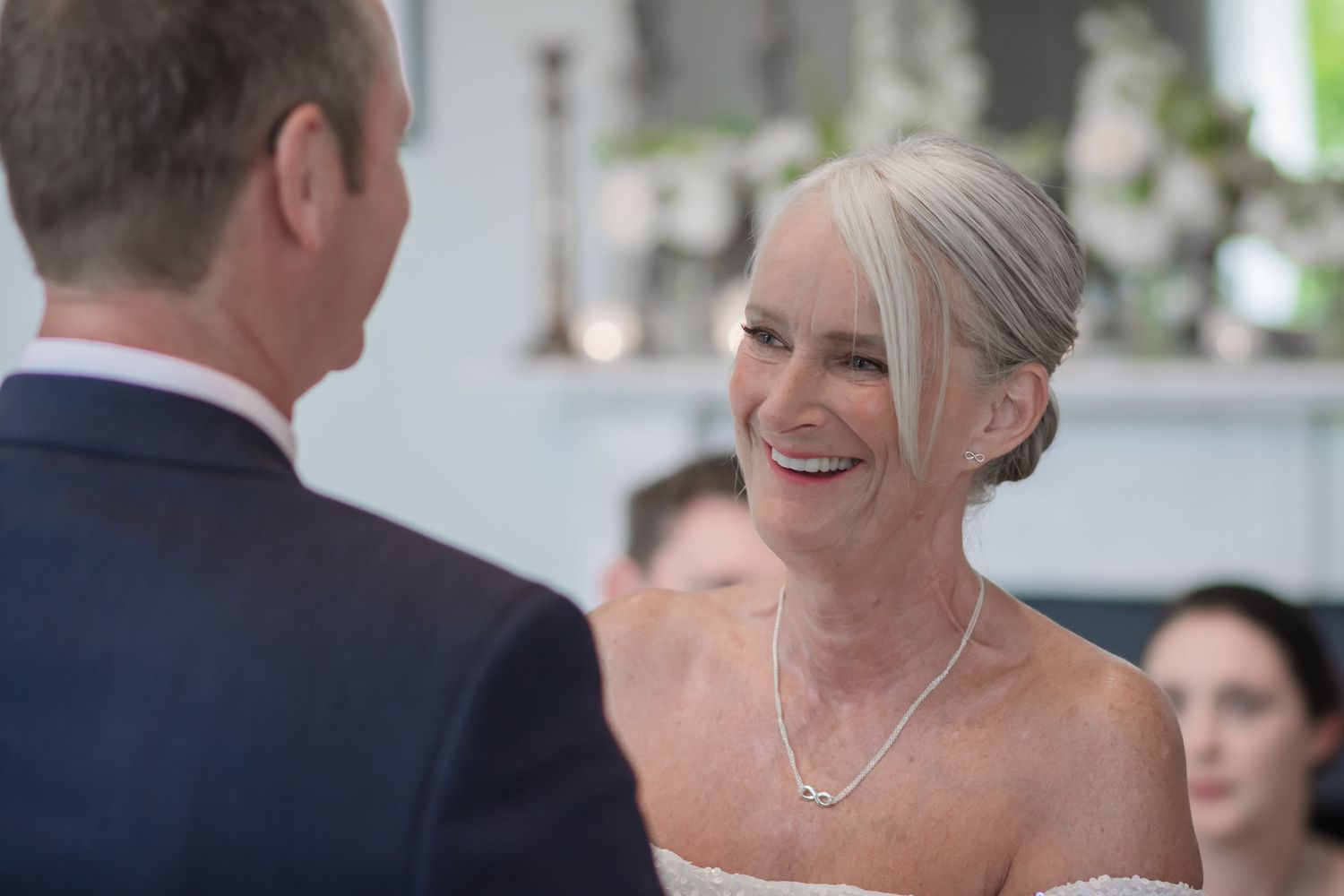 Joyful bride in a strapless white wedding dress during her ceremony at De Vere Cranage Estate;  wedding photography by Michael Pardoe
