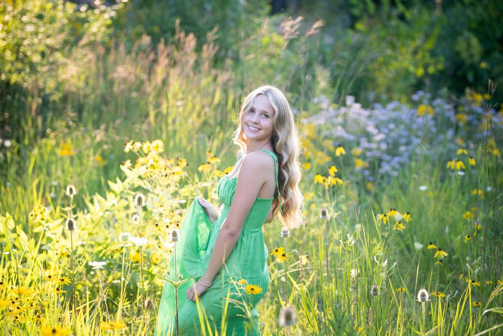Vibrant green dress contrasts beautifully against yellow wildflowers in a summer field.