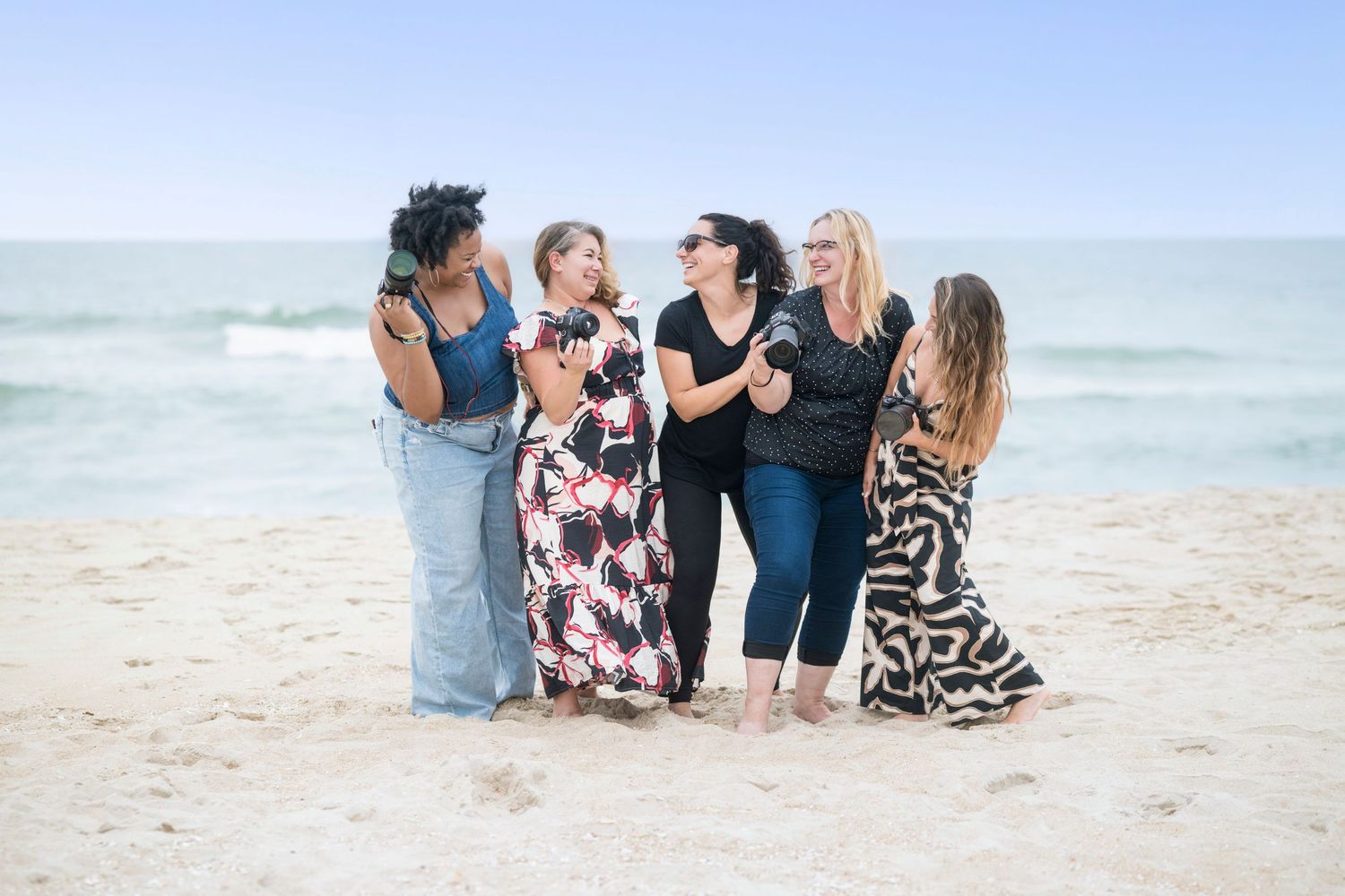 Group sitting together on a sunny beach enjoying a casual moment by the ocean.