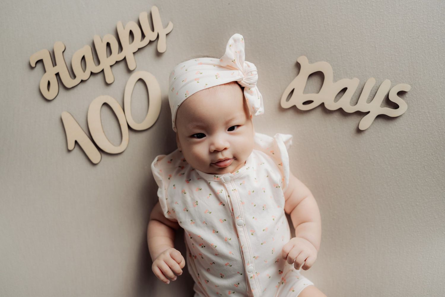 Birthday celebration setup with elegant wooden decorations and white backdrop.