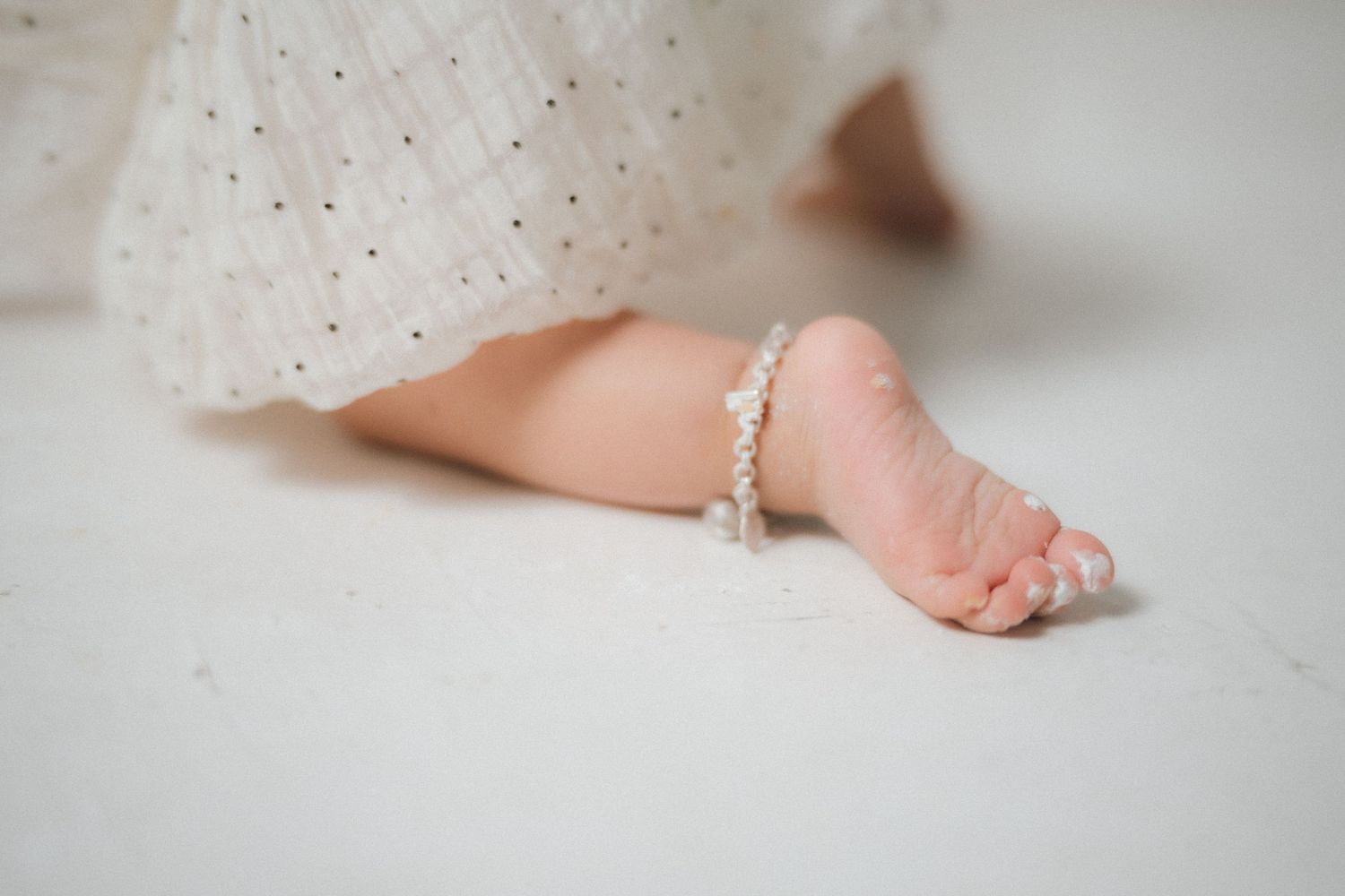 Close-up of sparkly details on white lace dress during photoshoot.