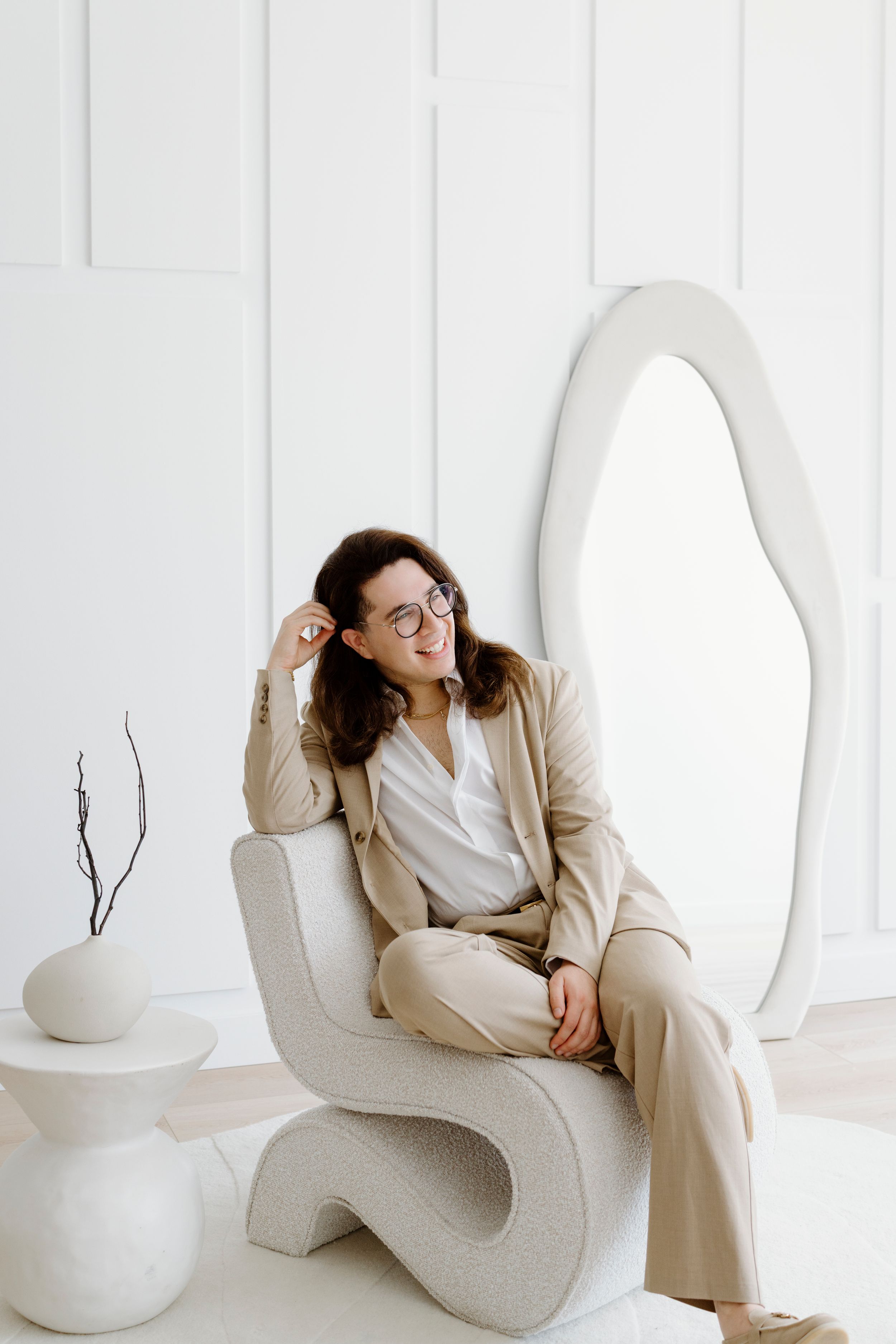 Modern minimalist scene with curved white seating and decorative vases.