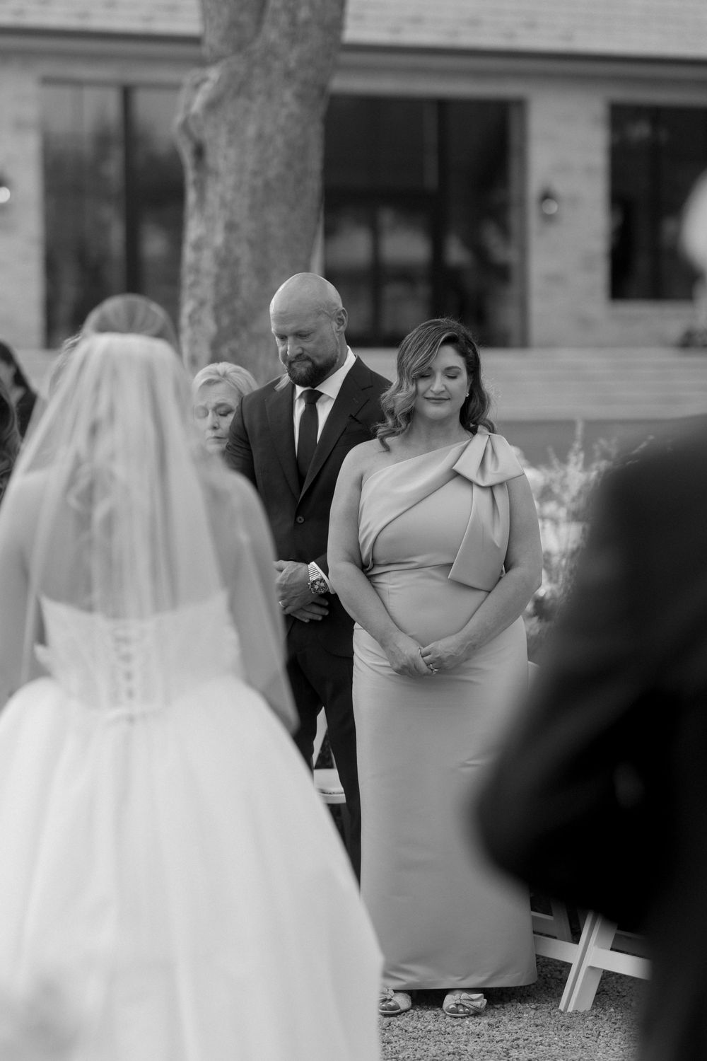 A series of black and white wedding ceremony moments showing the bride in a white dress with guests and attendants.