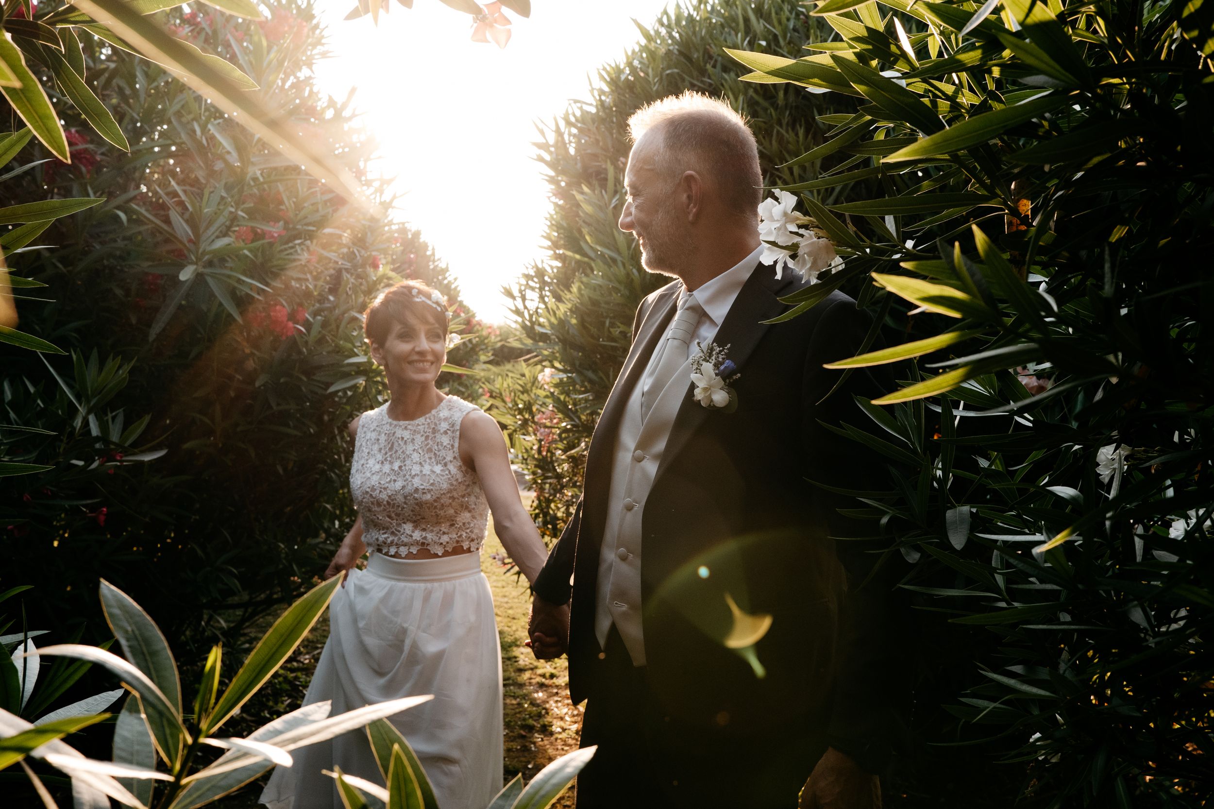 Wedding party members share emotional moments and laughter in a rustic venue with natural light streaming through windows.