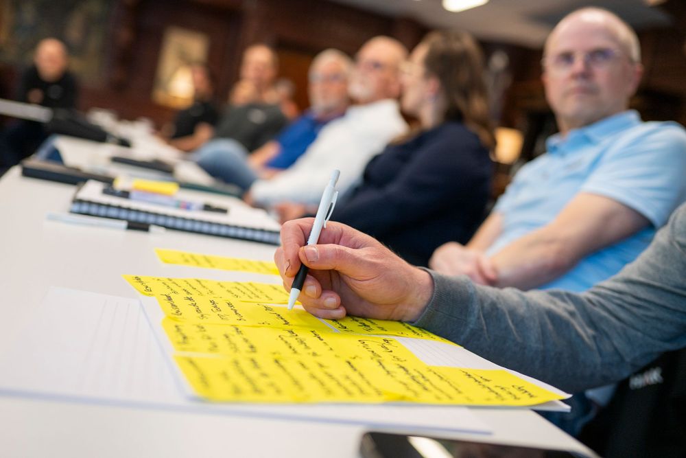People reviewing documents and taking notes during a business meeting.
