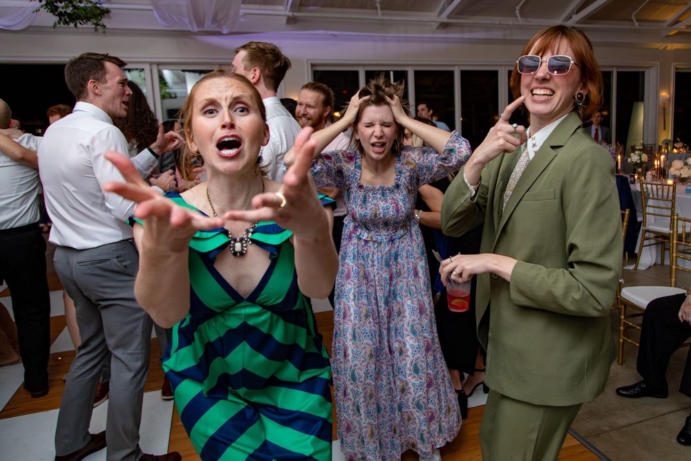 People dancing and celebrating at an indoor party with joyful expressions and energetic movements.