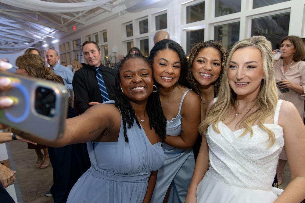 Wedding party taking a group selfie during celebration festivities.