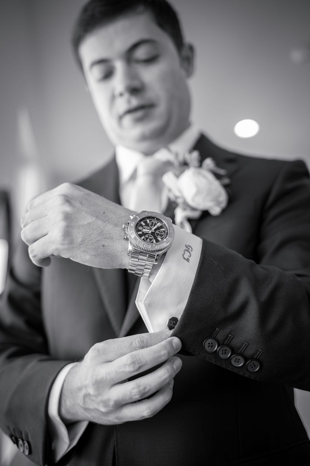 Black and white close-up sequence showing hands opening a ring box in formal attire.