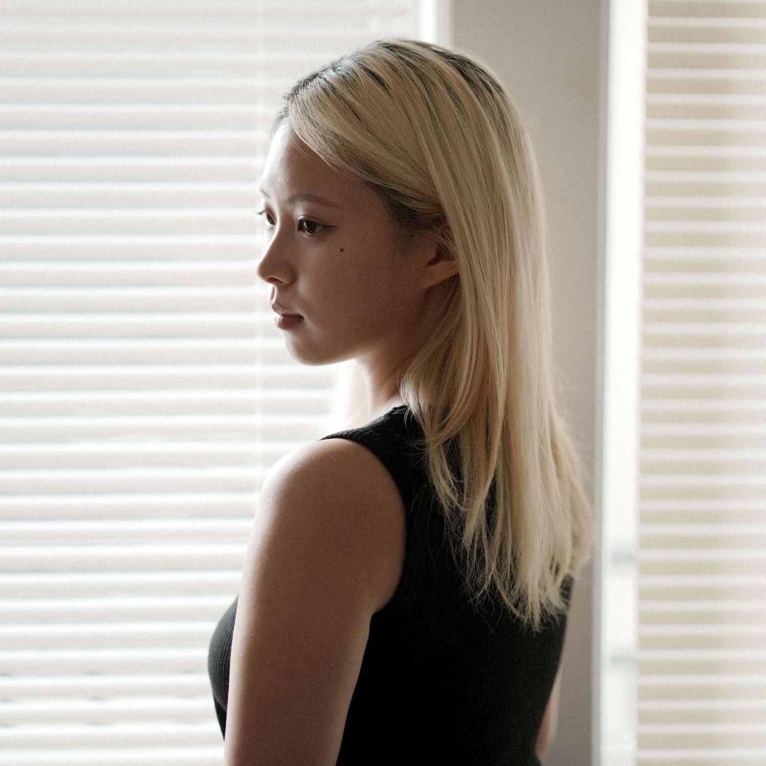 A series of black and white portraits showing a woman with blonde hair looking to the side near a window.