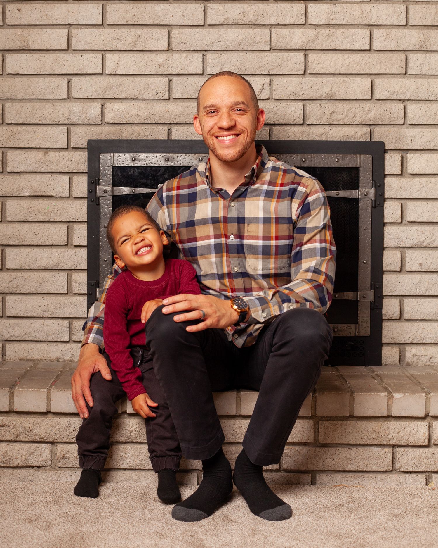 A series of four candid photos showing playful moments between an adult and child sitting on a brick ledge.