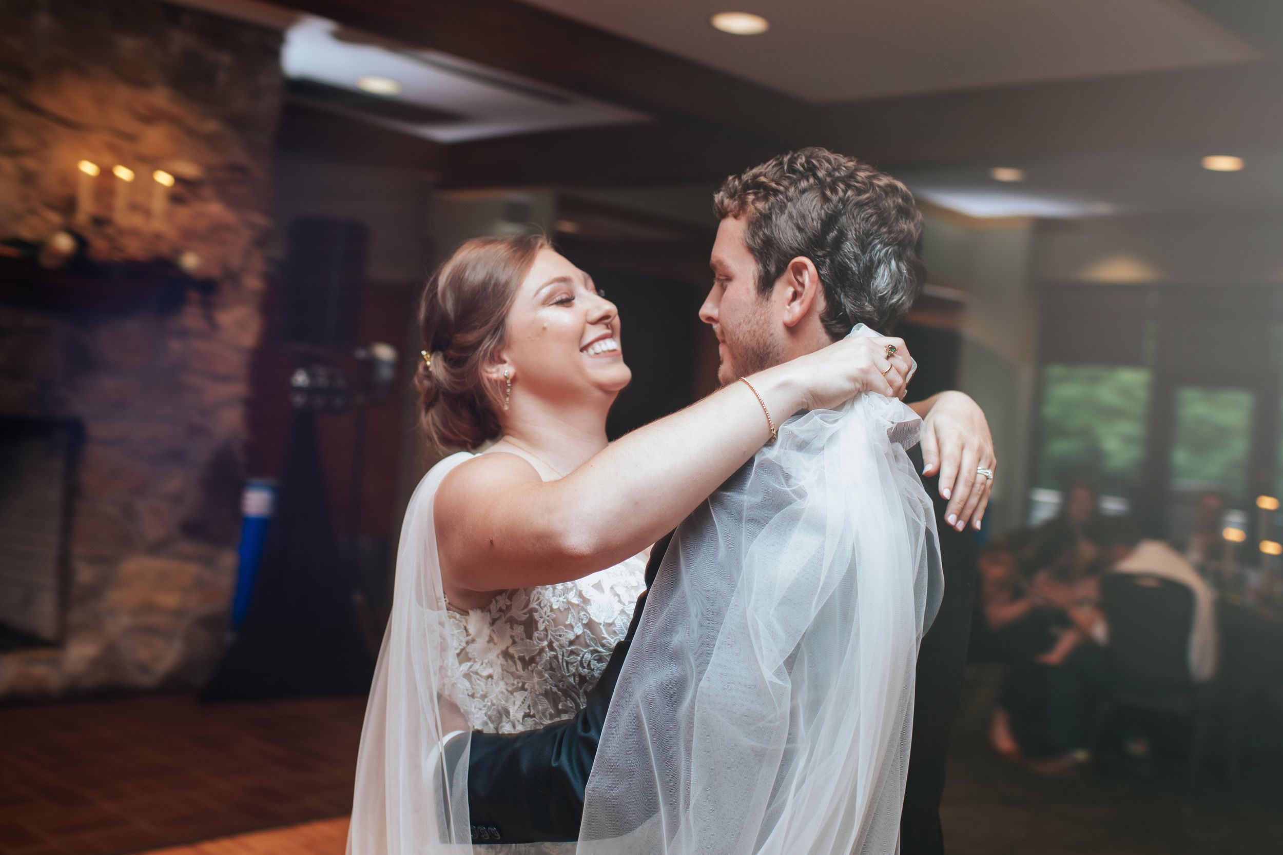 Newlyweds sharing a romantic dance moment in a rustic venue.
