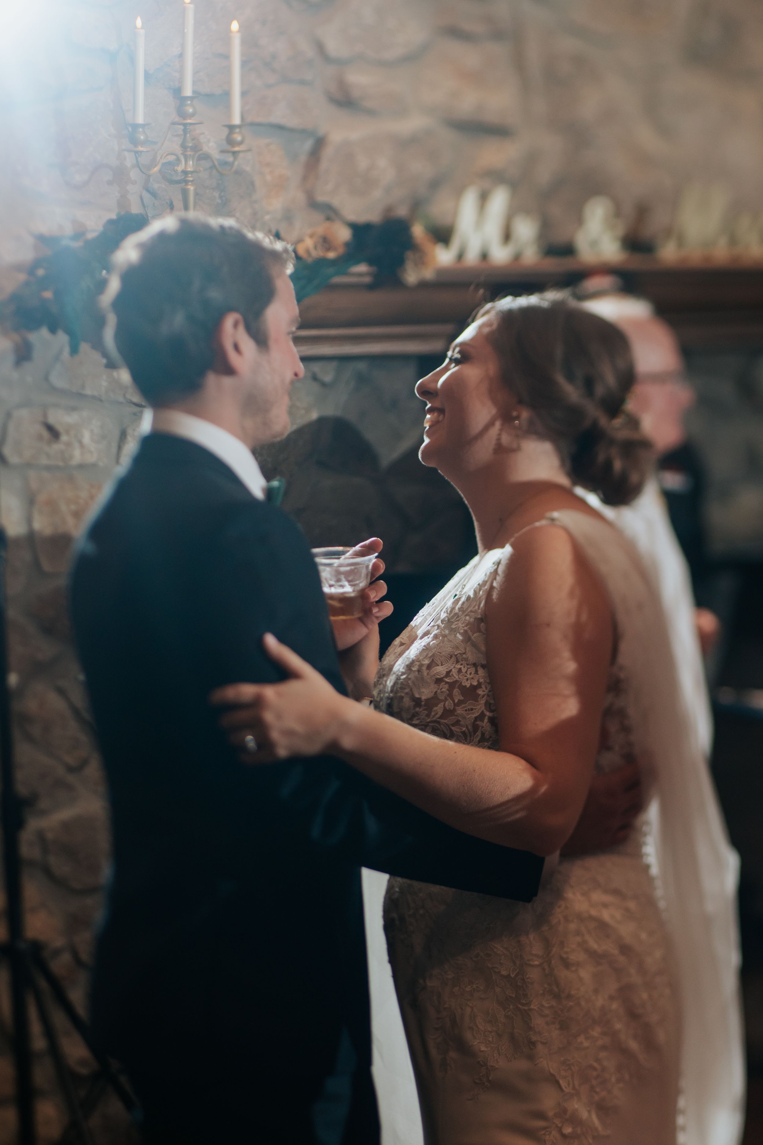 Couple sharing an intimate dance moment at a dimly lit wedding reception.
