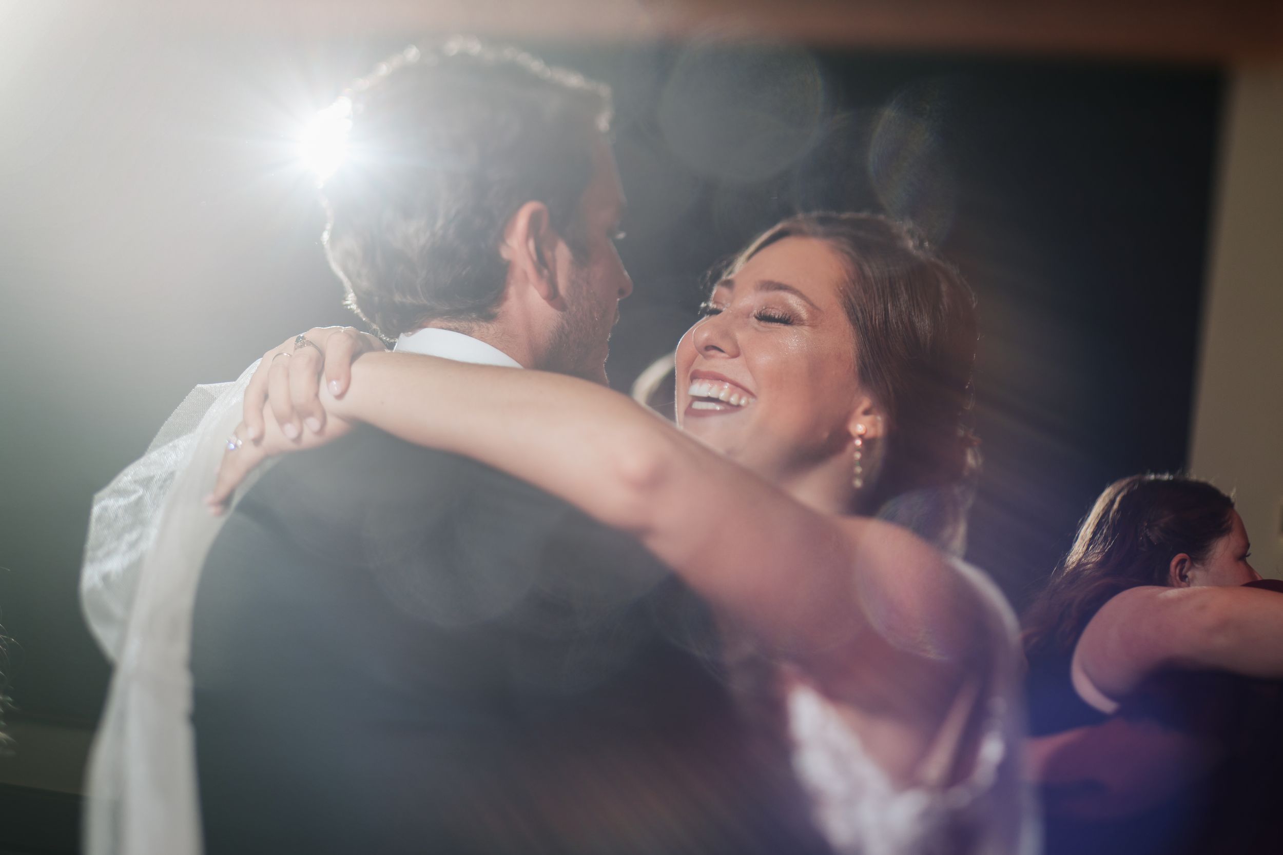 Couple embracing during their first dance at a wedding reception.