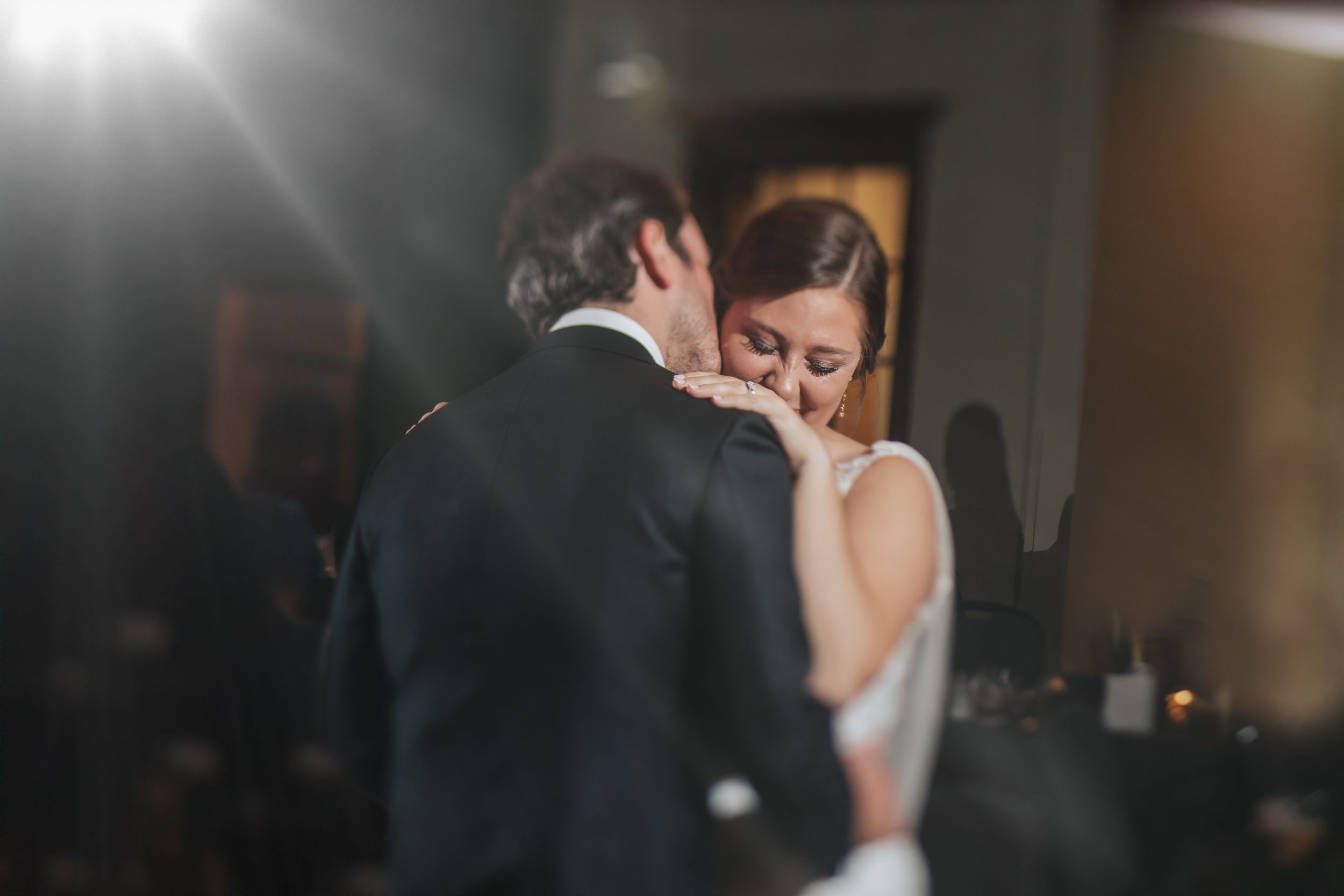 Wedding couple dancing in soft lighting at their reception.