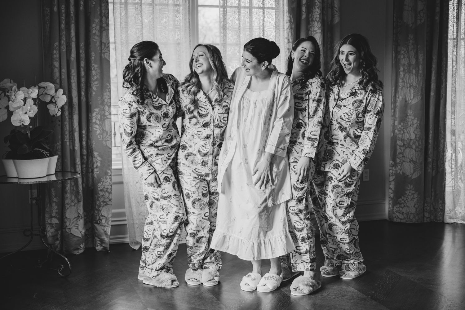 Group wearing matching floral print pajamas poses together in black and white.