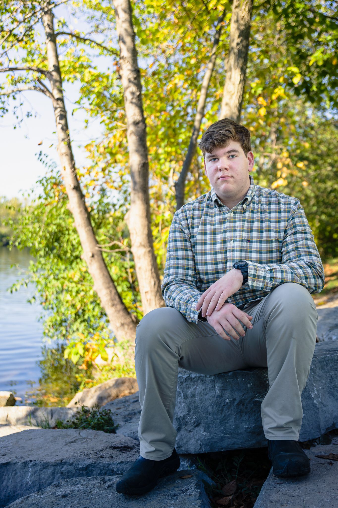 High school senior boy poses for a senior photo at Gallup Park in Ann Arbor.