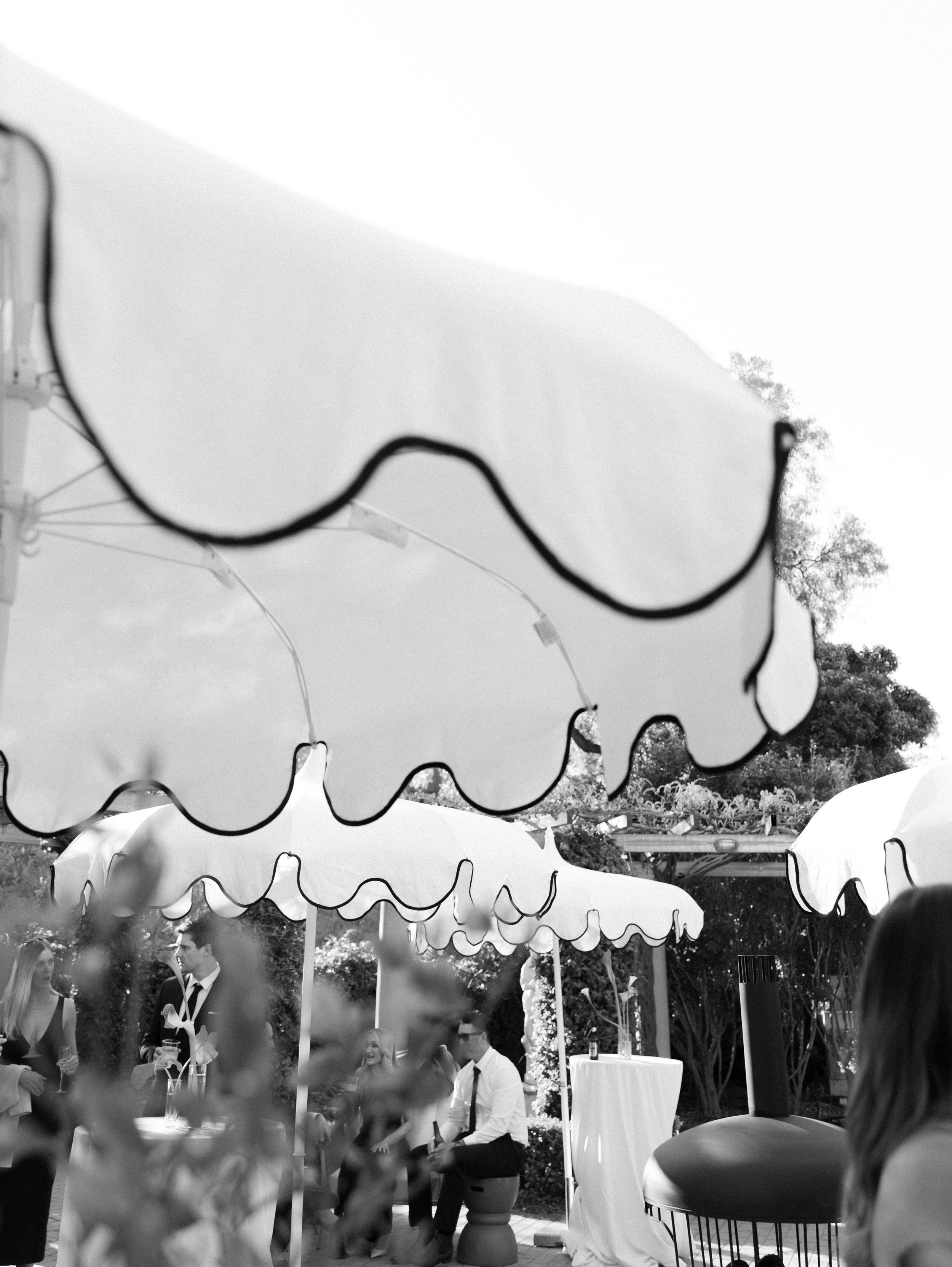 Black and white wedding reception tent with scalloped edges and elegant draping creates a romantic outdoor atmosphere.
