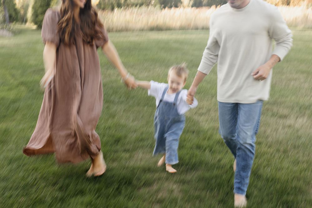 A slow motion photo of a happy family running in a field for family photos at Saltonstall Farm in Stratham, New Hampshire.