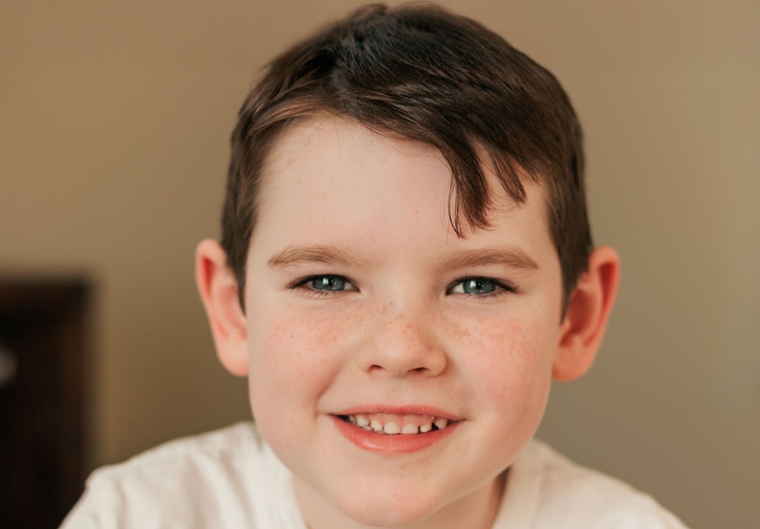 A close-up portrait of someone with a warm smile against a neutral background | Annual Birthday Photos for Kids