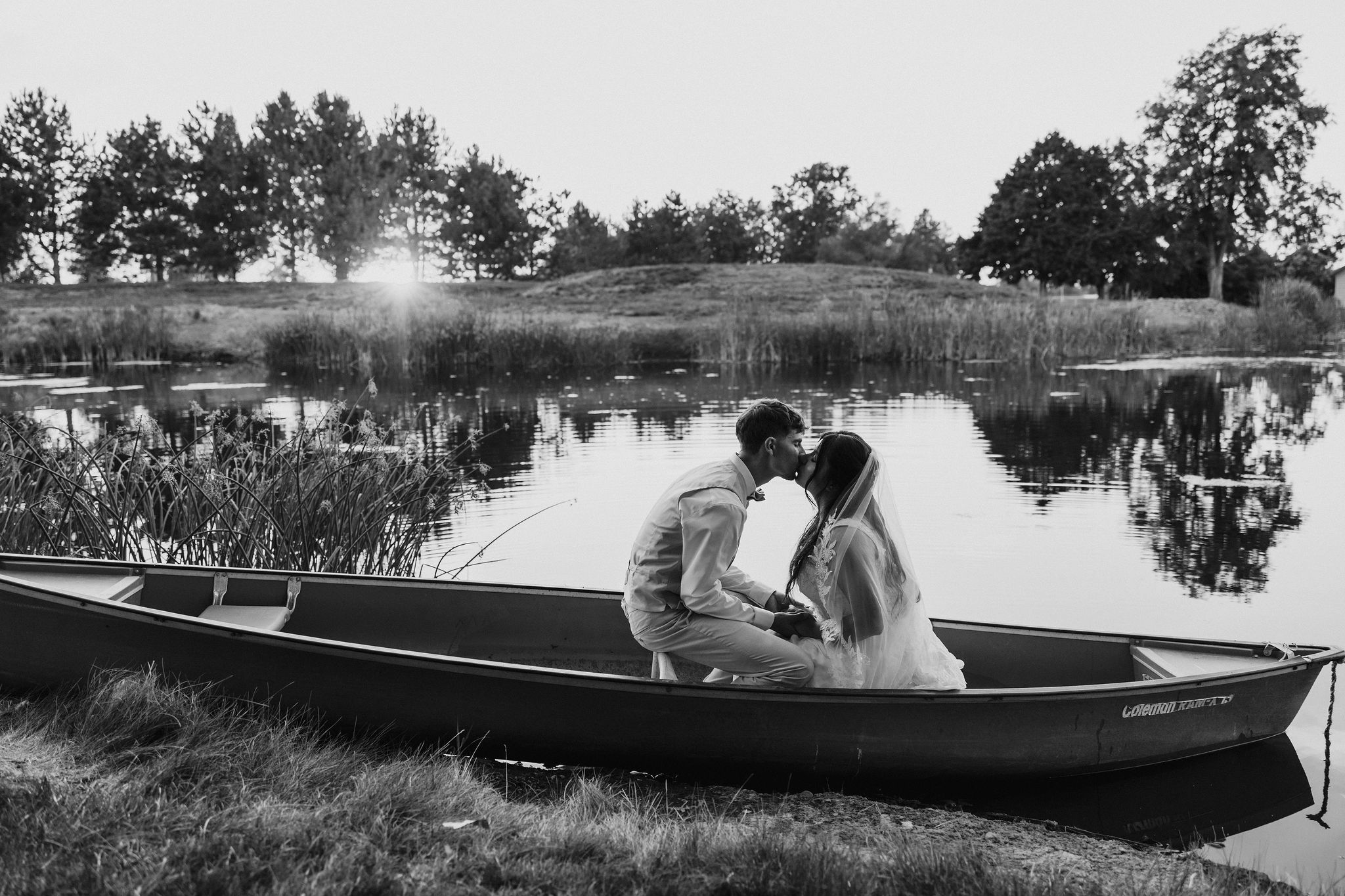 Sunset bride and groom portraits in a canoe on a pond