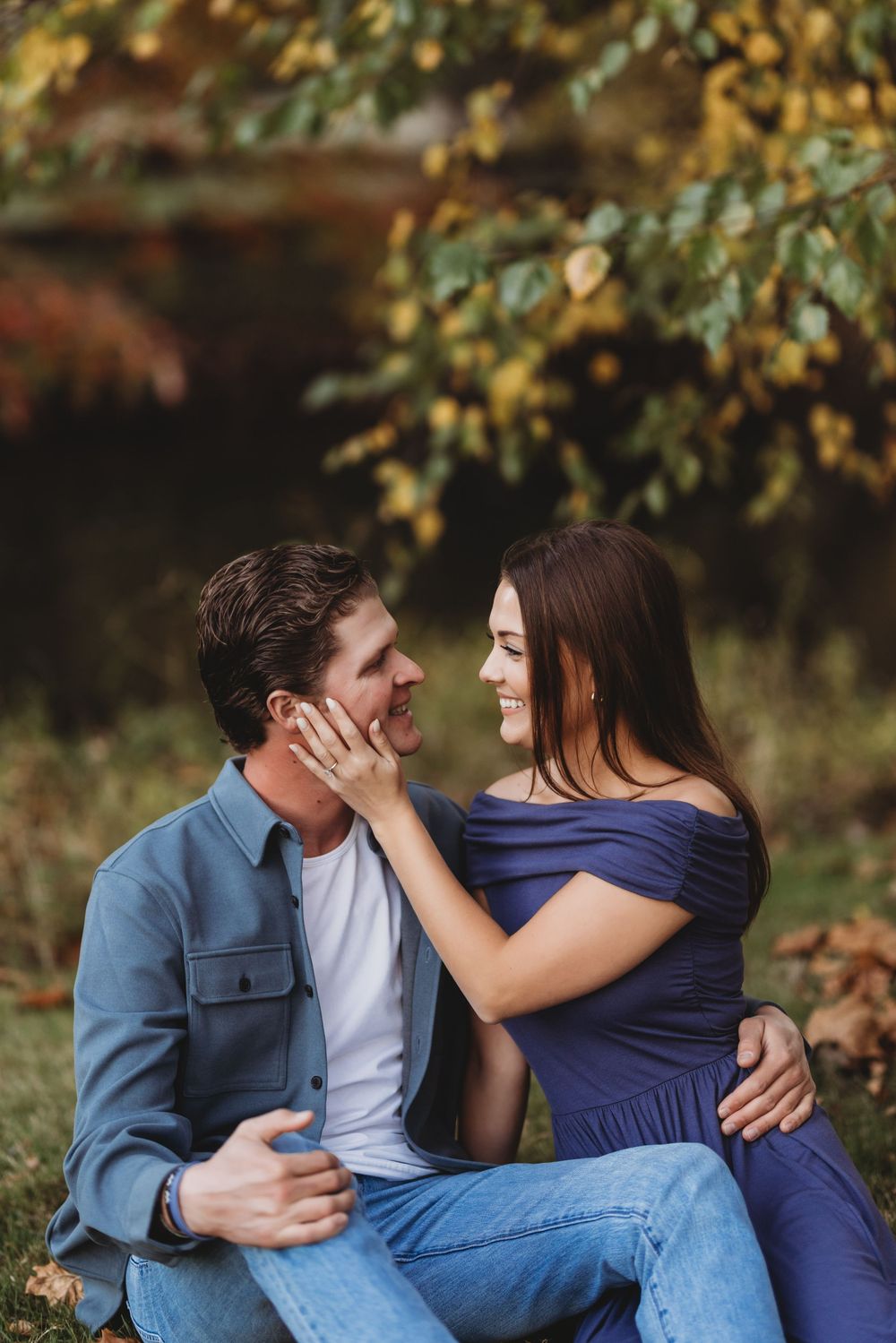 Couple in blue and navy outfits sharing romantic moments in an autumn setting.
