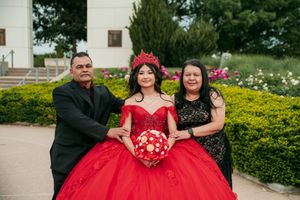 A festive celebration in a garden featuring a dramatic red ball gown and formal attire.