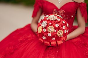 Close-up details of an ornate red dress showing intricate floral embroidery and beadwork.