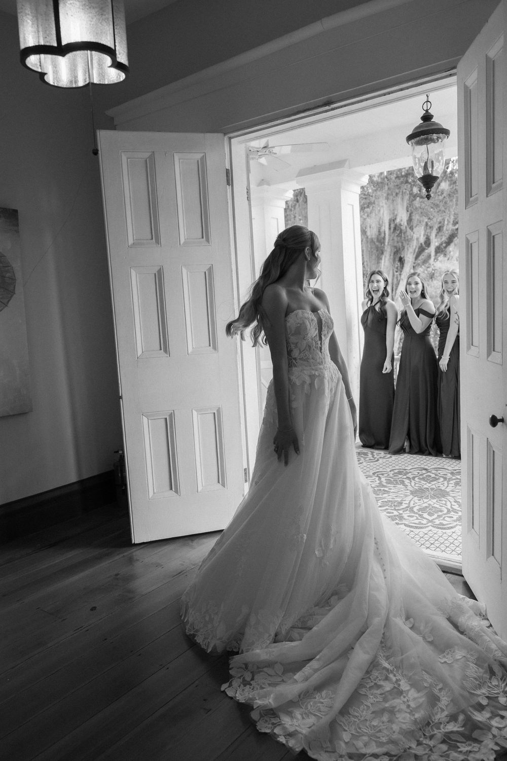 Bride and bridesmaids first look moment on the balcony of the historic mansion in Coosada, Alabama