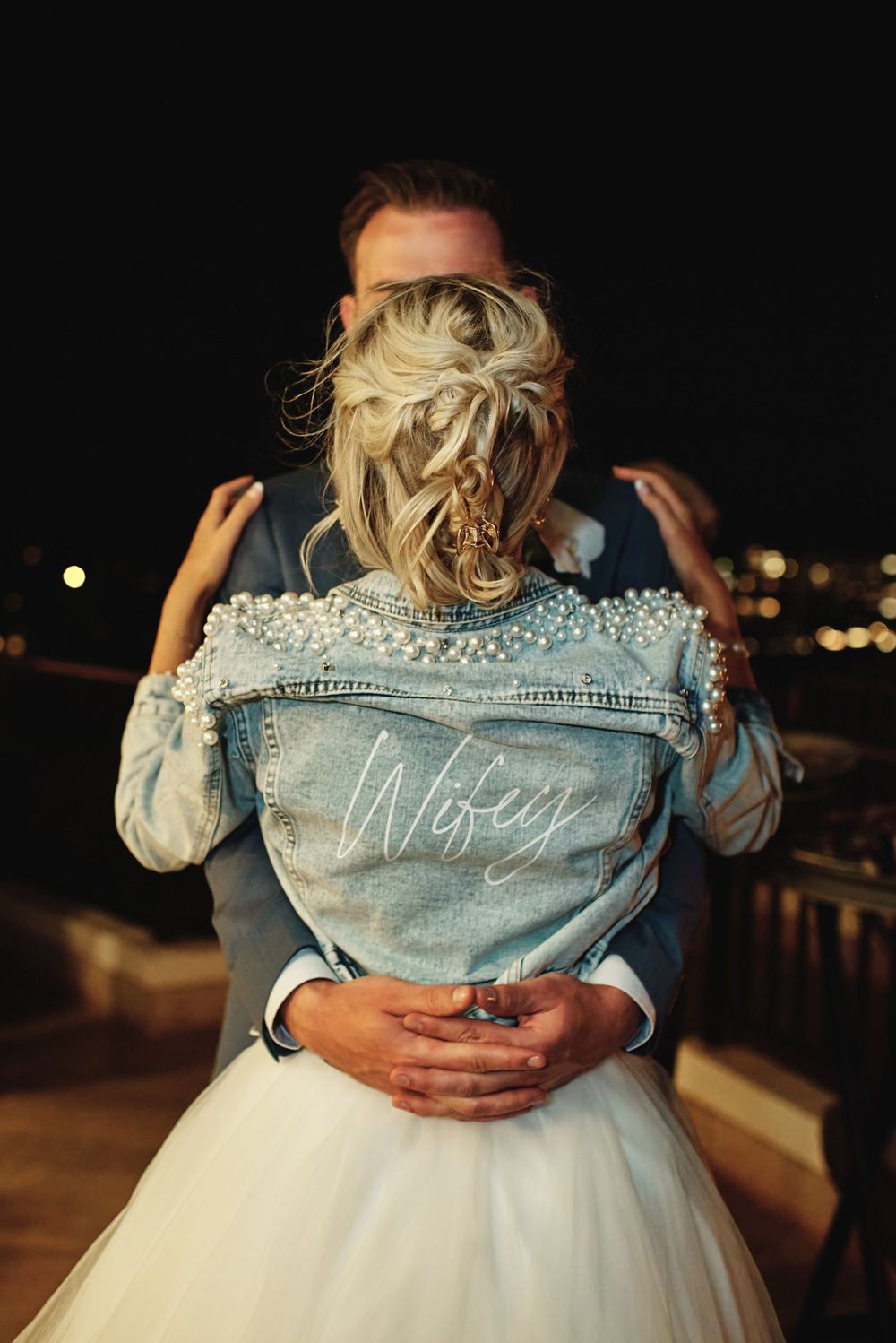 A customized denim jacket with 'Wifey' text displayed at a wedding.