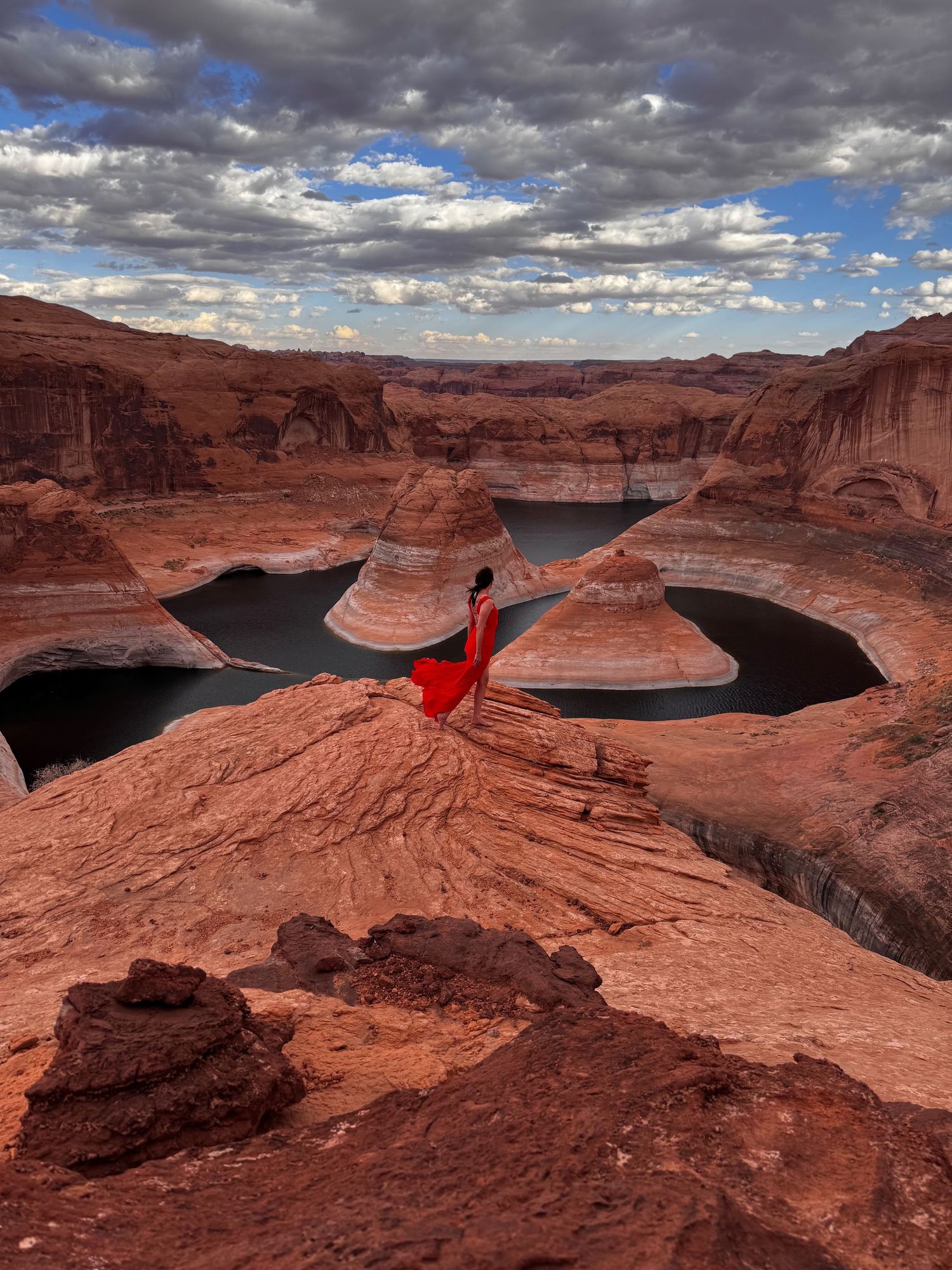 Dramatic view of Lake Powell's Reflection Canyon with red rock formations and dramatic cloudy sky at Glen Canyon. Kristen Lusk photographer