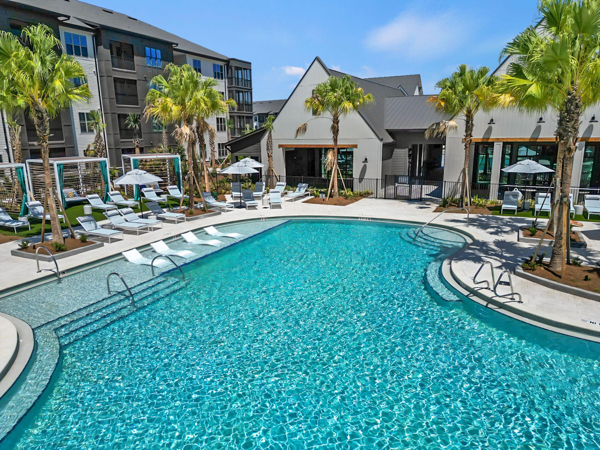 Luxury pool at Everwell at Bexley in Land O' Lakes, FL, featuring cabanas, lounge seating, and palm trees, managed by Rangewater Real Estate