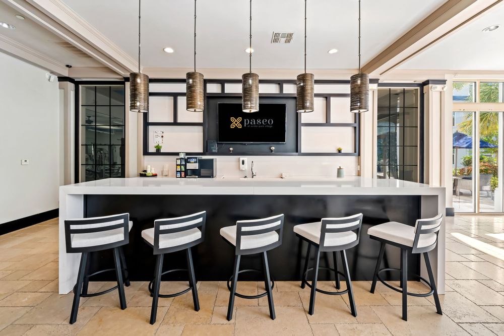 Clubhouse kitchen at Paseo at Winter Park Village, FL, with bar seating, pendant lights, and counters, perfect for resident events.
