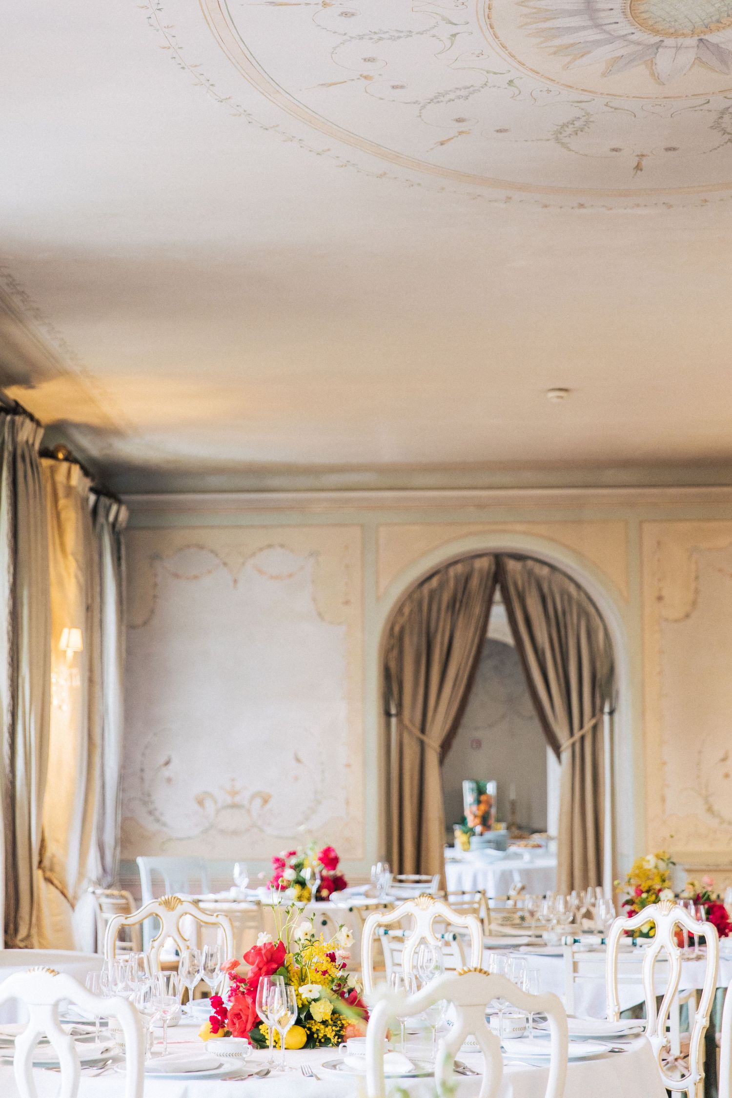 Elegant wedding reception table setting with colorful floral centerpieces and decorative ceiling at Valverde Sintra Palácio de Seteais.