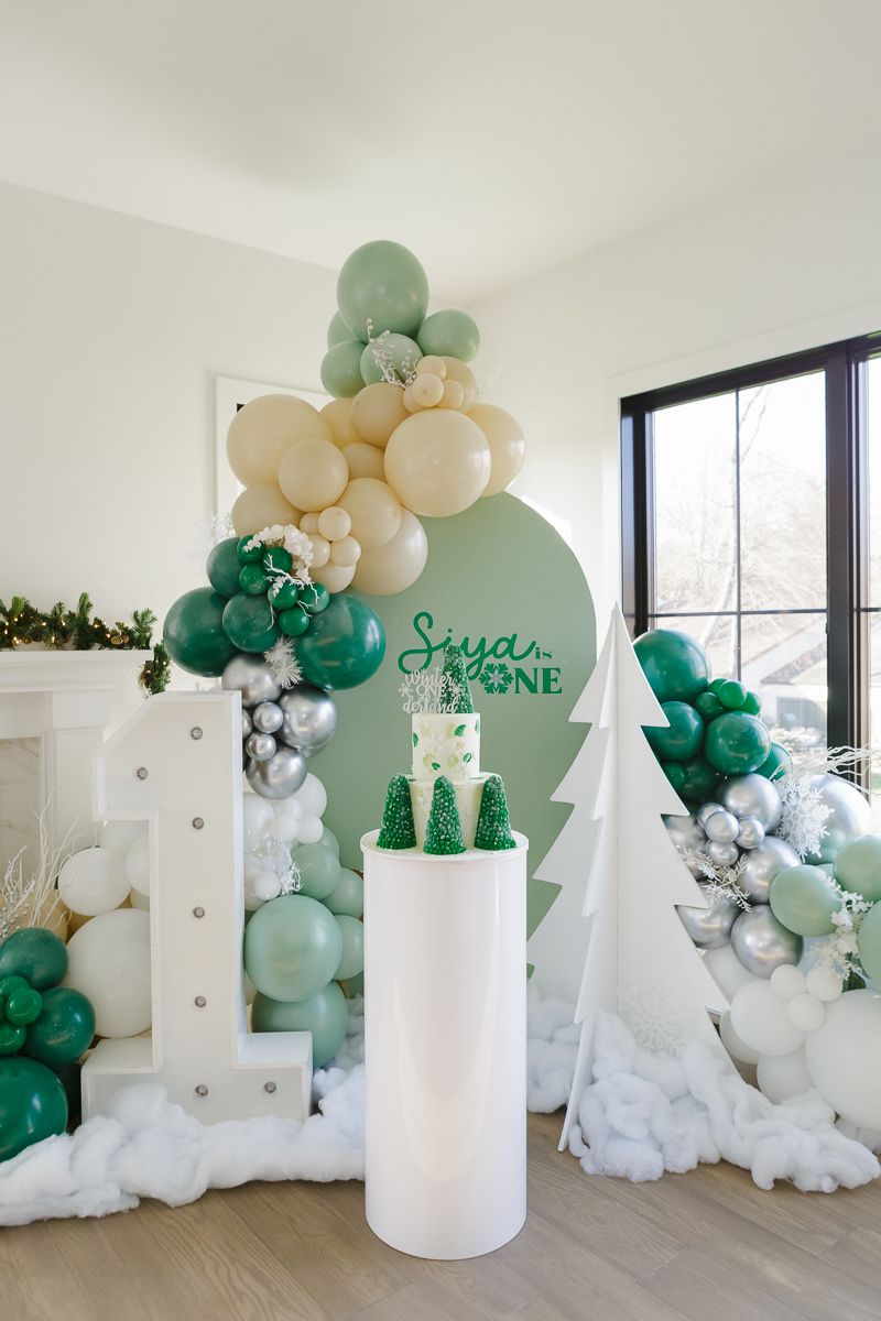 Festive 'Winter ONEderland' first birthday setup with balloons, a cake, and decorations. Captured by NYC family photographer Paula Brearley.