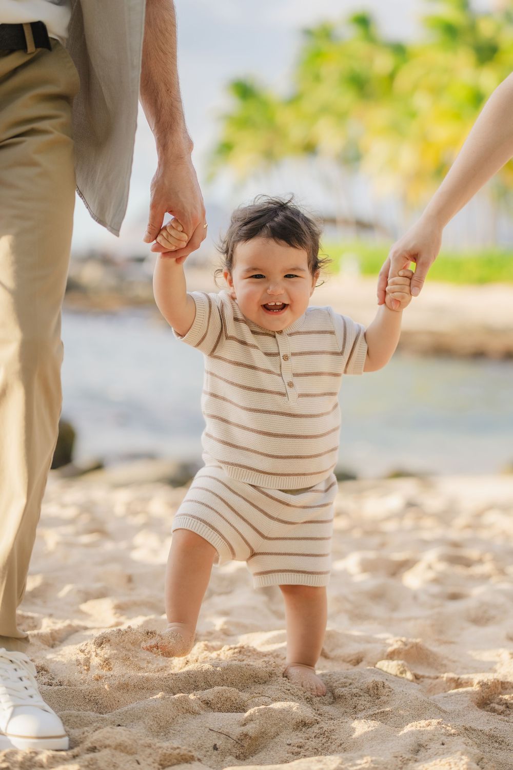 A series of photos showing small feet walking on beach sand while being supported by adult hands.