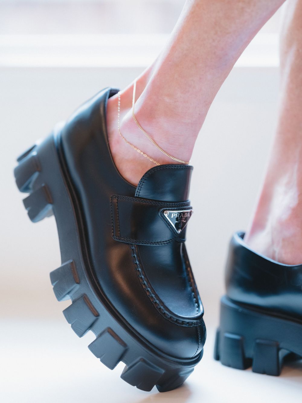Chunky black platform loafers with thick treaded soles shown on feet.