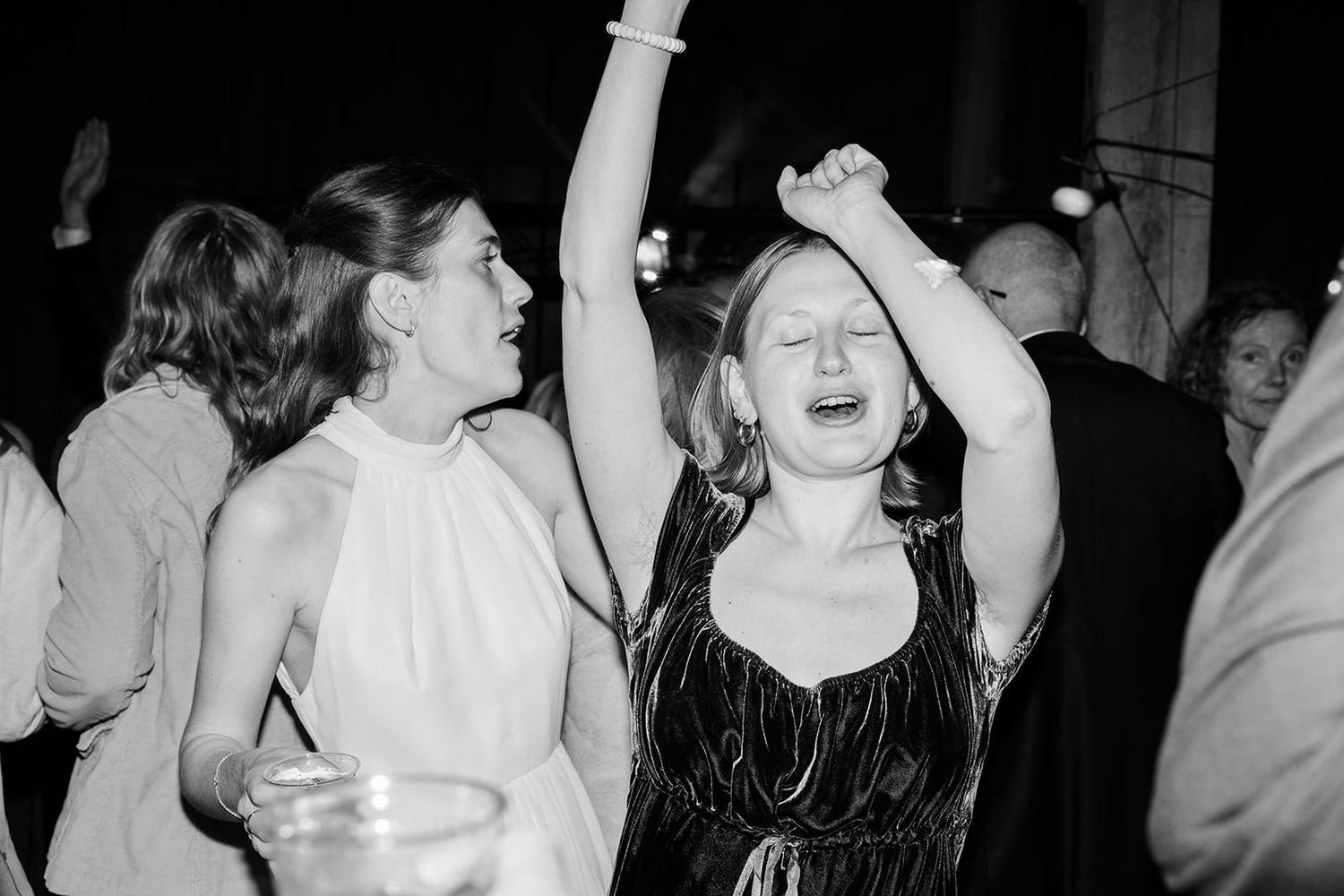 A person in a flowing white dress dances expressively in a dark room, captured in a series of dynamic movements.