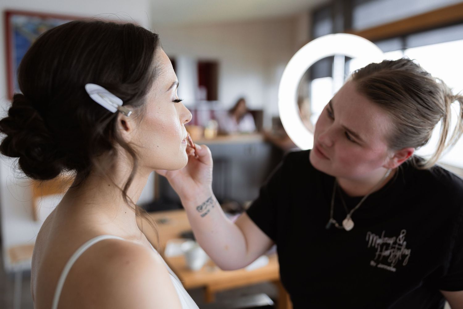 A bride gets her hair and makeup done while preparing for her wedding day.