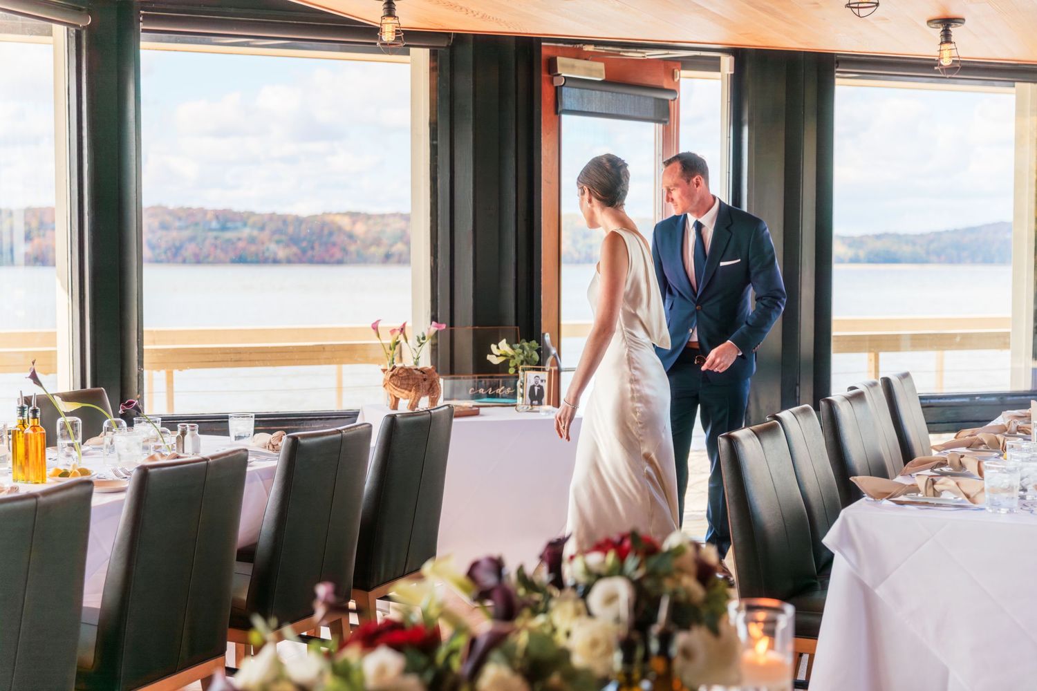 Bride and groom enter their reception space for the first time. Bride is looking back at the groom.