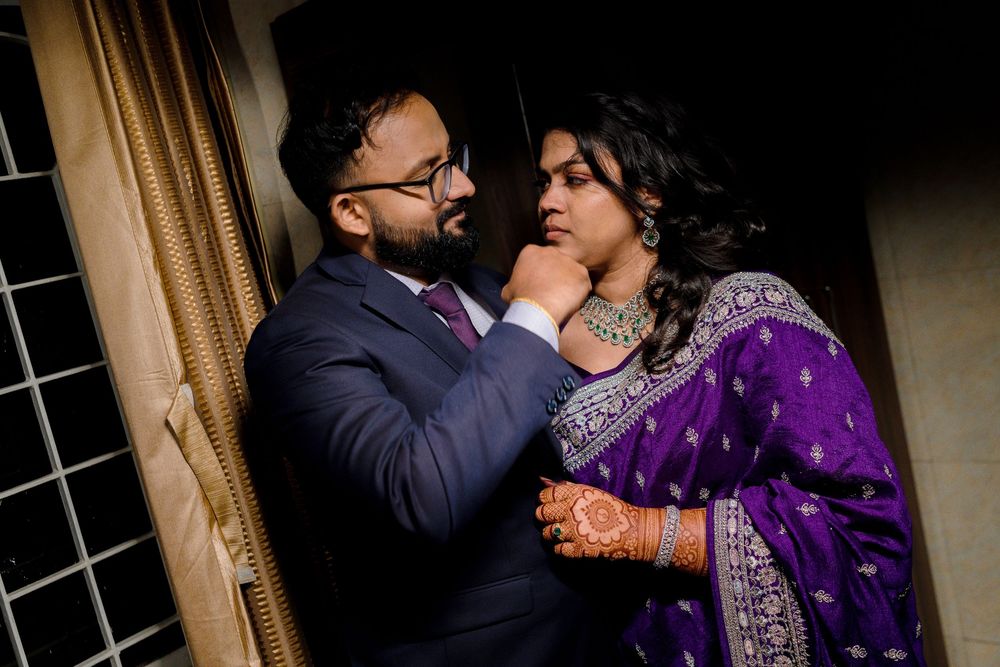 A couple in traditional Indian attire dance together at an elegant indoor venue.