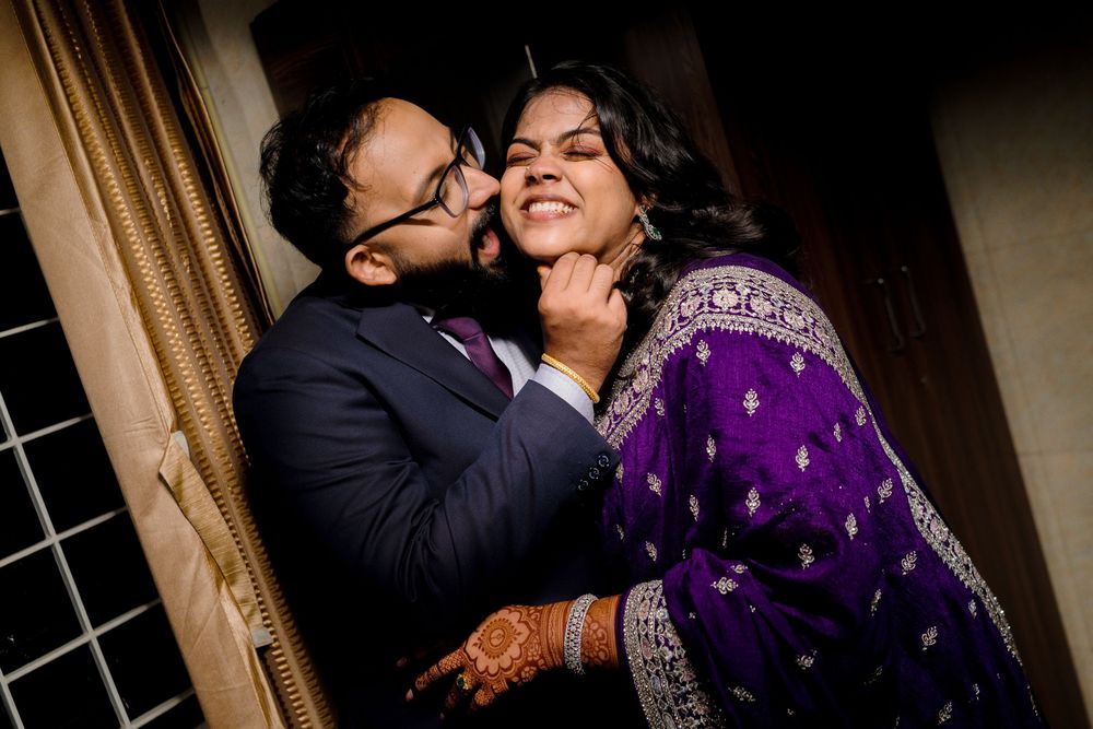 A romantic couple shares an intimate moment in formal attire against a dark background.