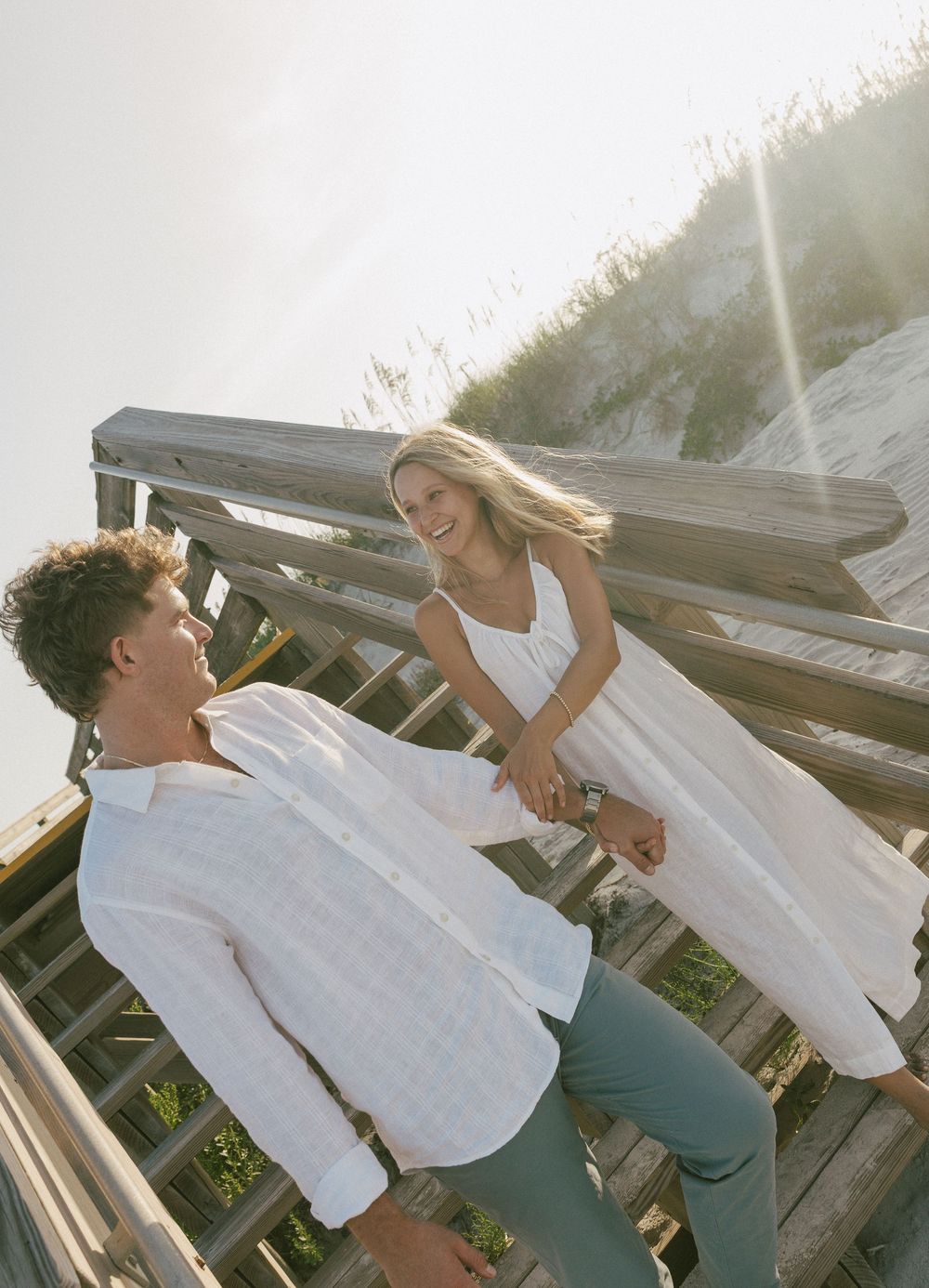 A sequence of playful dance moves on a wooden deck at sunset with light flares in the background.