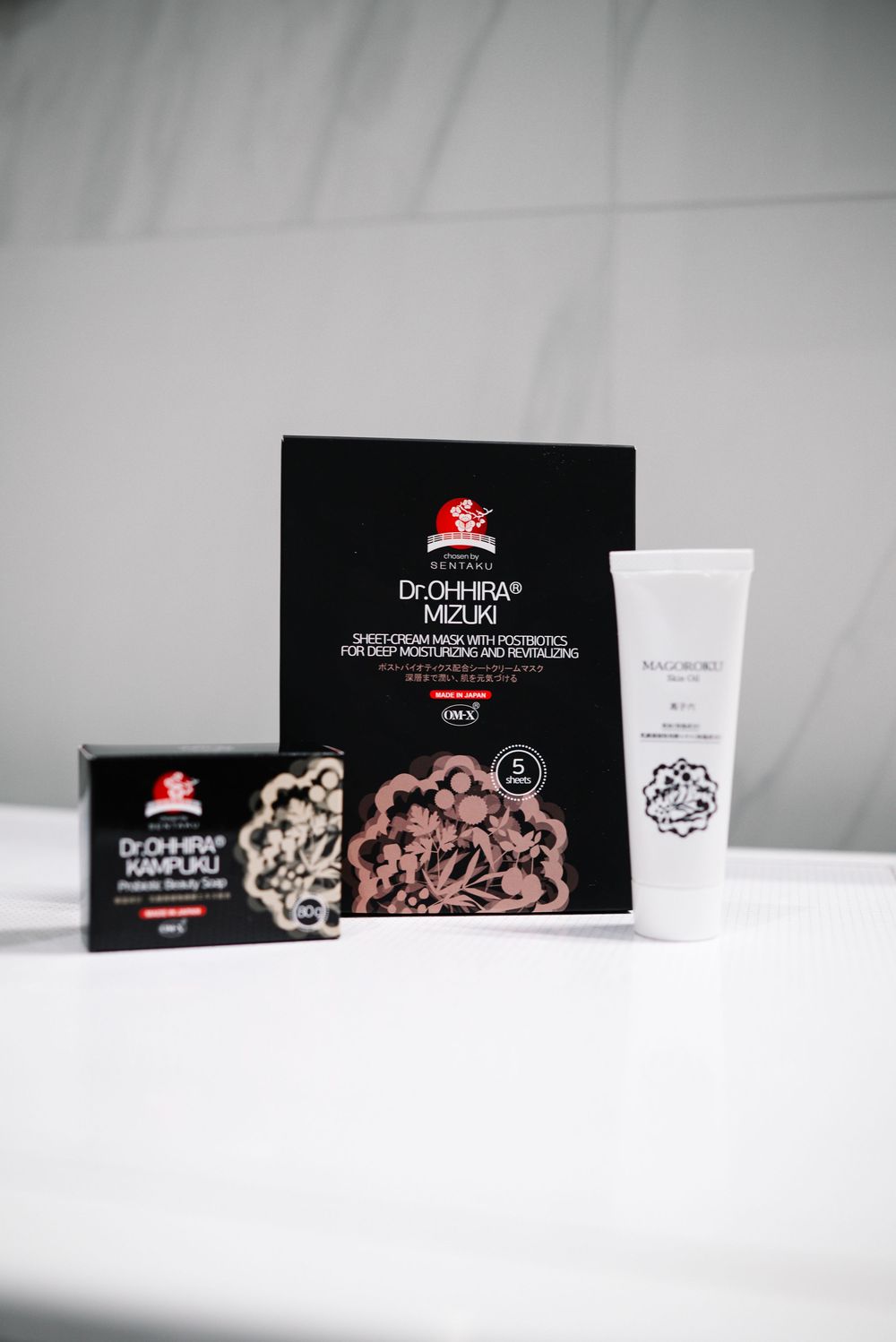 Dr. Ohhira Kampuku beauty soap, Mizuki sheet mask box, and white skincare tube displayed on white surface.