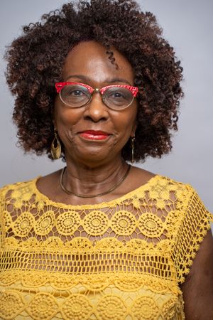 Three headshots show a person in a yellow crochet top wearing stylish glasses and natural curly hair.
