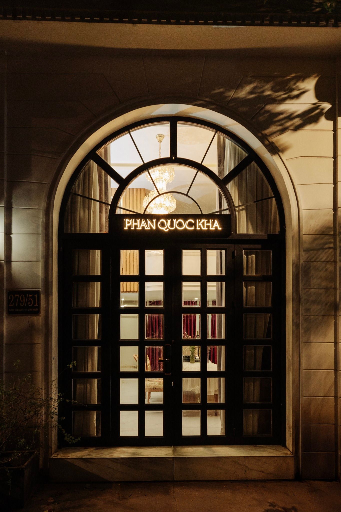 Elegant arched entrance of Phan Quoc Kha venue glowing warmly at night.