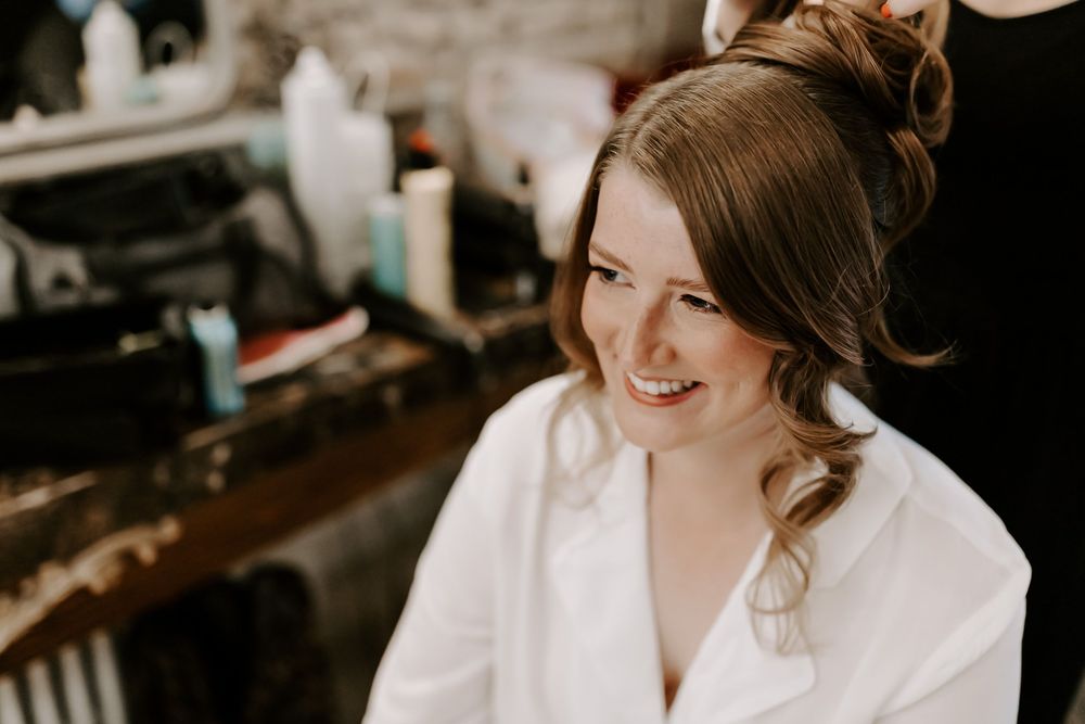 A wedding party getting ready in white robes and casual attire before the ceremony.