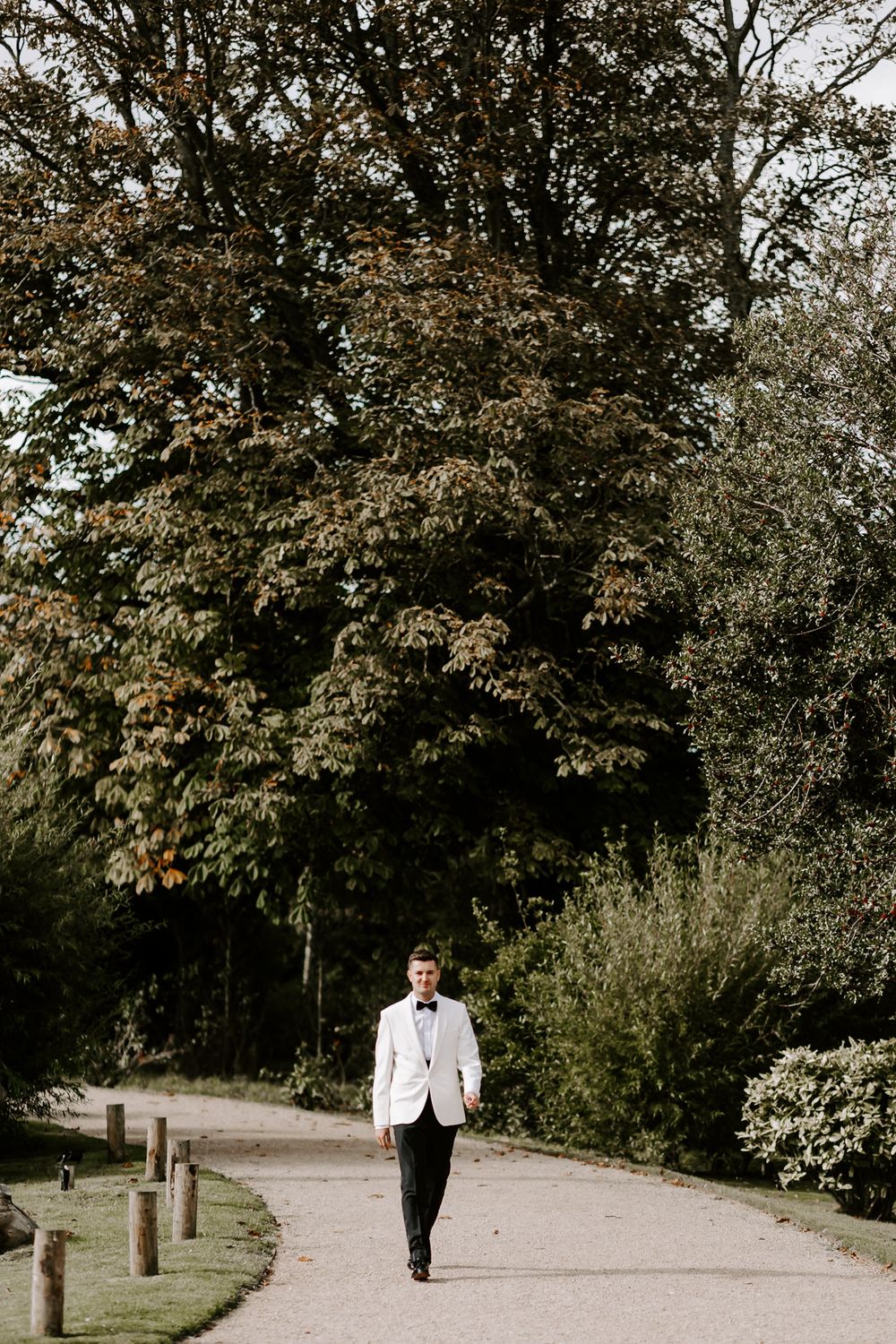 A sequence of photos showing two people in formal attire walking along a winding path through a wooded park area.
